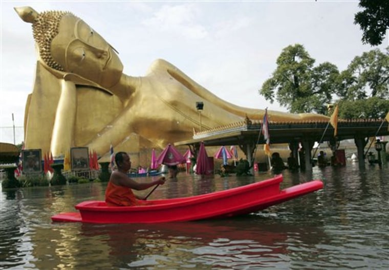 A Buddhist monk rows his boat past a giant Buddha image at a flooded temple in Ayutthaya province, central Thailand Wednesday, Oct. 20, 2010. The death toll from flooding in Thailand rose to five on Tuesday. Downpours that started over the weekend have affected nearly 55,000 people in 17 central and northeastern provinces, according to the Disaster Prevention and Mitigation Department. (AP Photo)